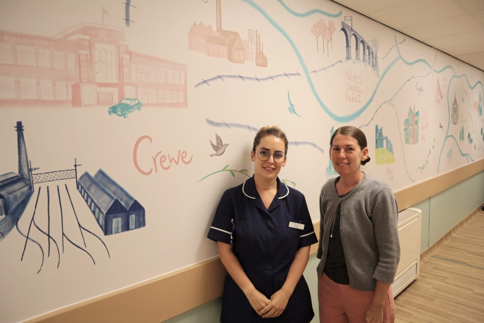 ward manager and artist stand in front of new artwork for FEAU 