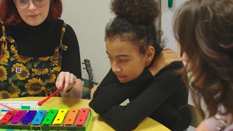 Little girl plays musical instrument